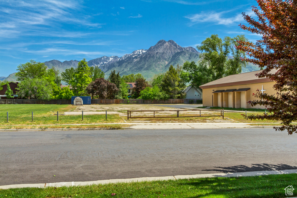 View of asphalt road featuring a mountain view and curbs
