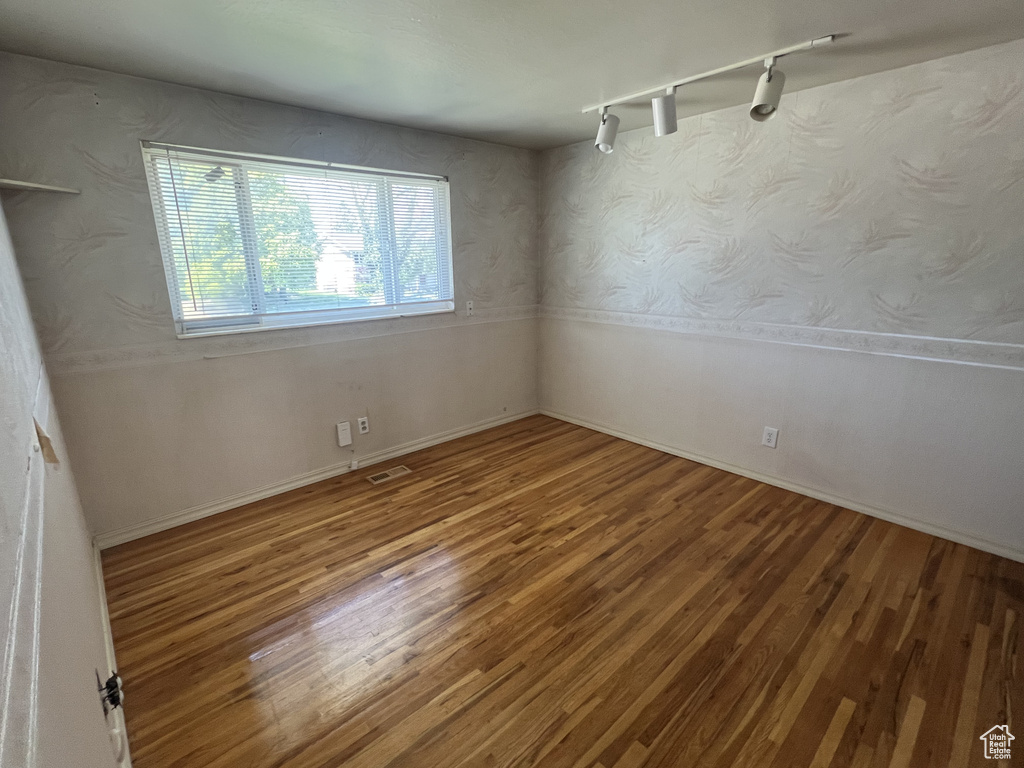 Spare room featuring wood finished floors and track lighting