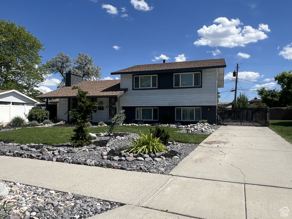 Tri-level home featuring a chimney and driveway