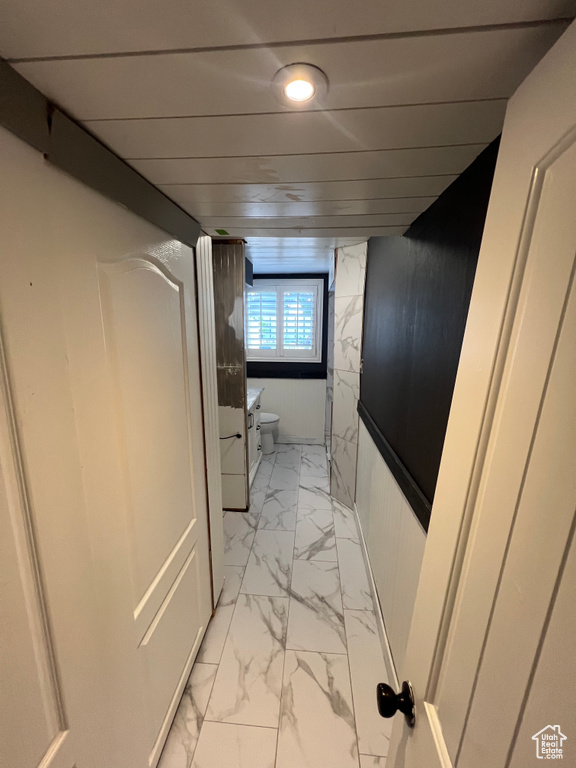 Hallway with light marble finish flooring and recessed lighting