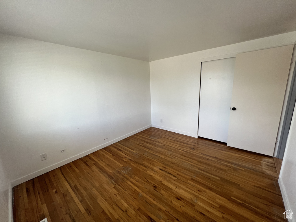 Unfurnished room with wood-type flooring and baseboards