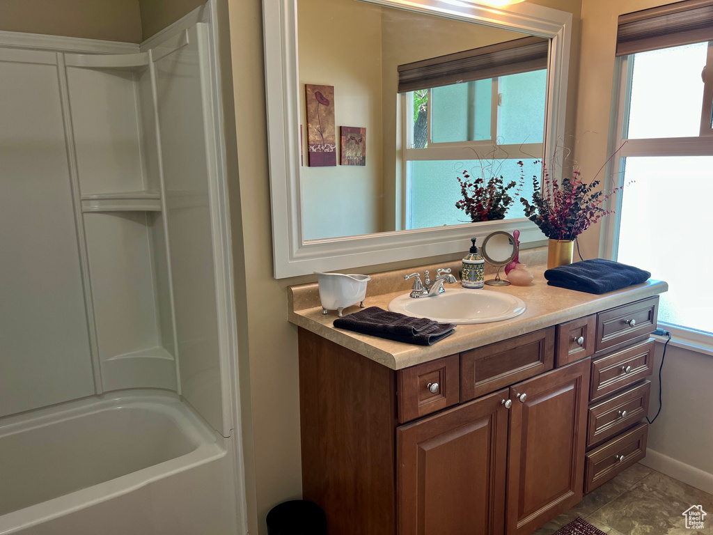 Full bathroom with vanity, a bathtub, and a shower