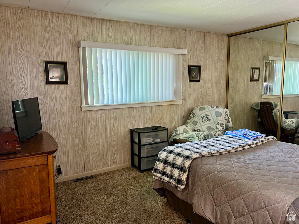 Carpeted bedroom featuring baseboards and a closet