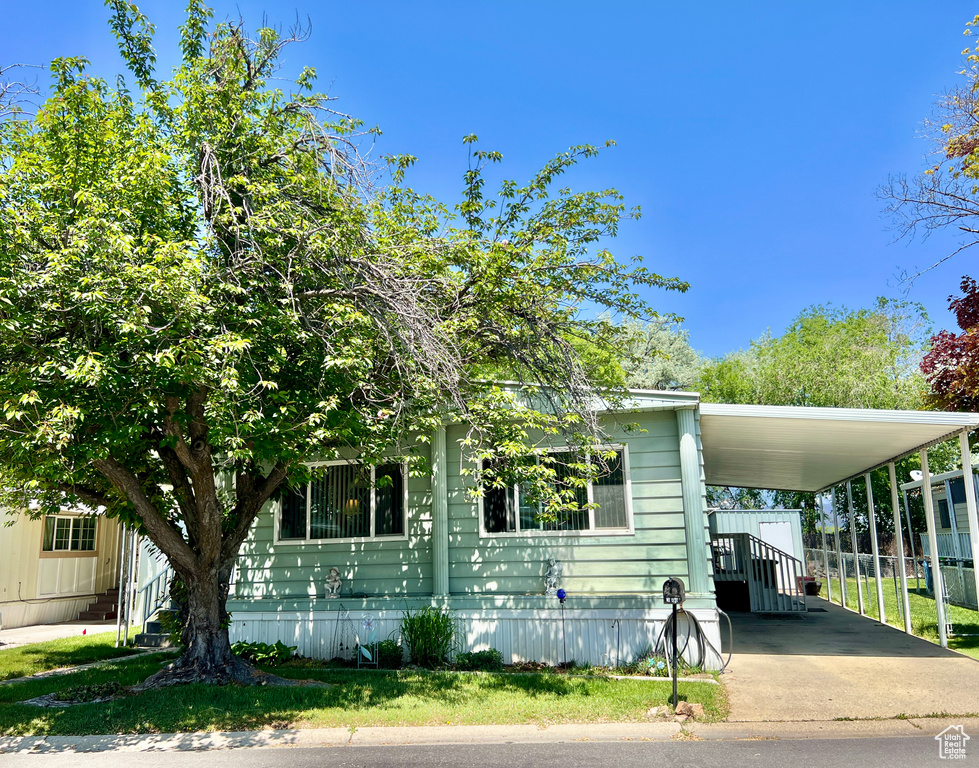 View of front of home featuring an attached carport and concrete driveway