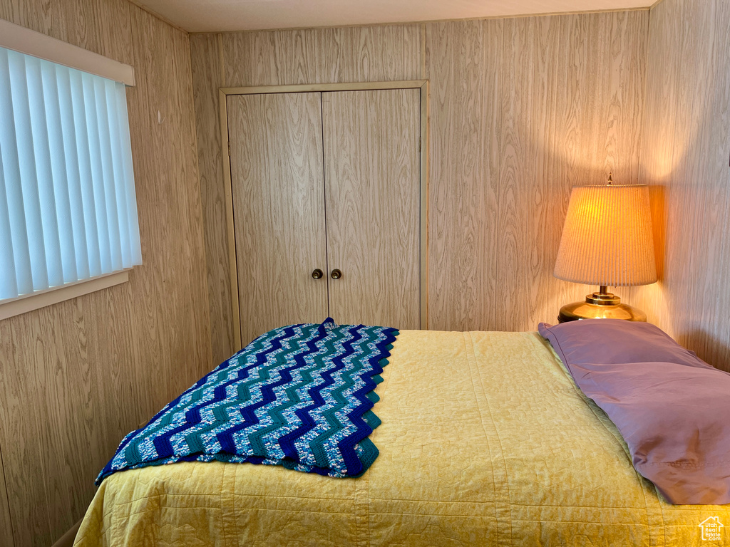 Bedroom with a closet and wood walls