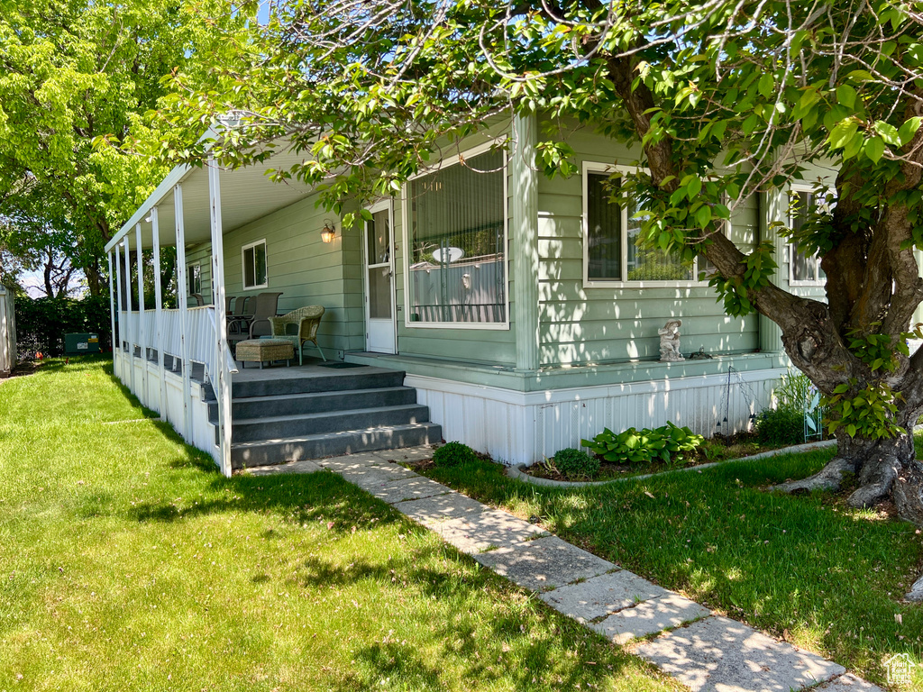 View of home\\\\\\\'s exterior with covered porch and a yard