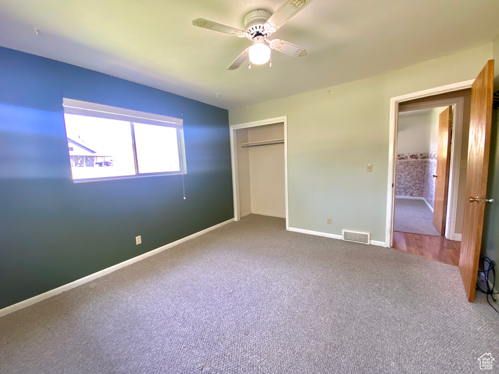 Unfurnished bedroom with carpet floors, a closet, baseboards, and ceiling fan