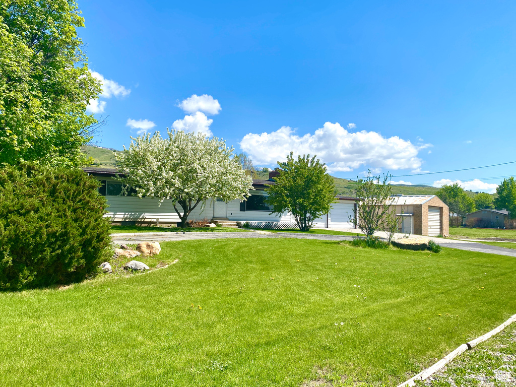 View of front of home featuring a front lawn, asphalt driveway, and an attached garage