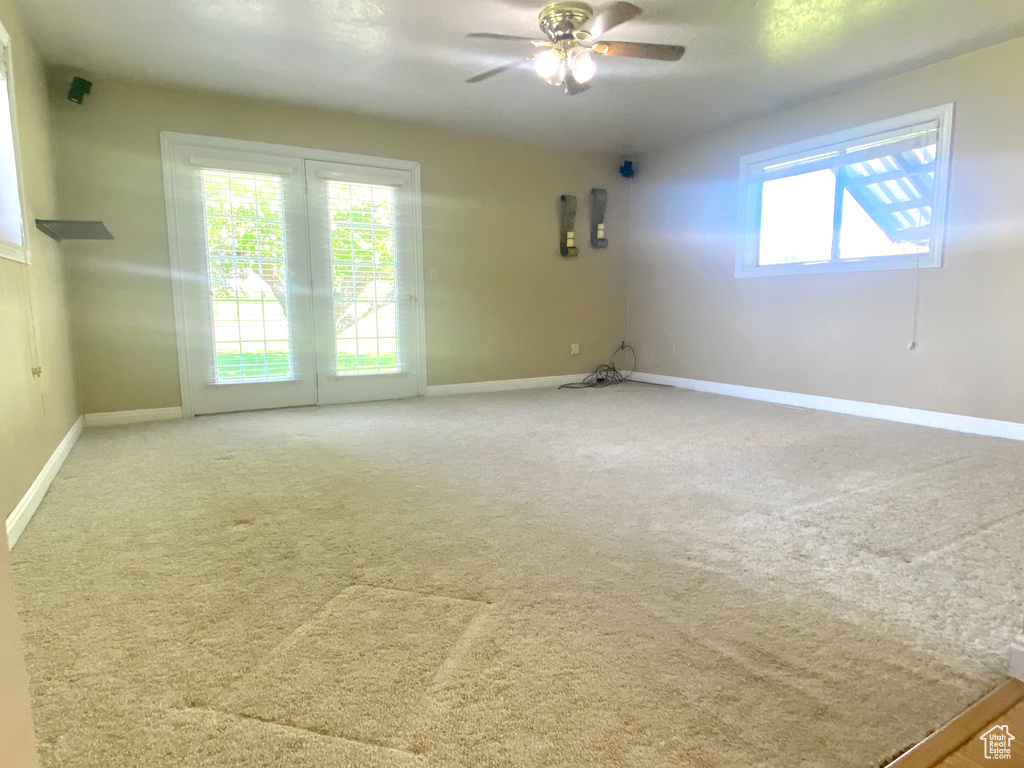 Spare room featuring ceiling fan, baseboards, and carpet