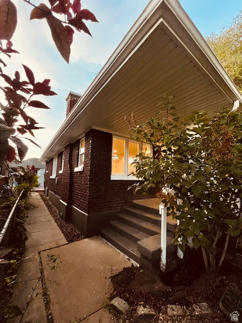 View of property exterior with brick siding and a chimney