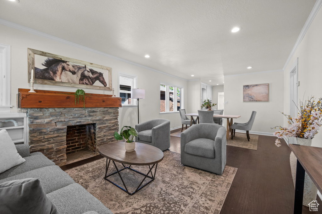 Living room featuring crown molding, recessed lighting, wood finished floors, a fireplace, and baseboards