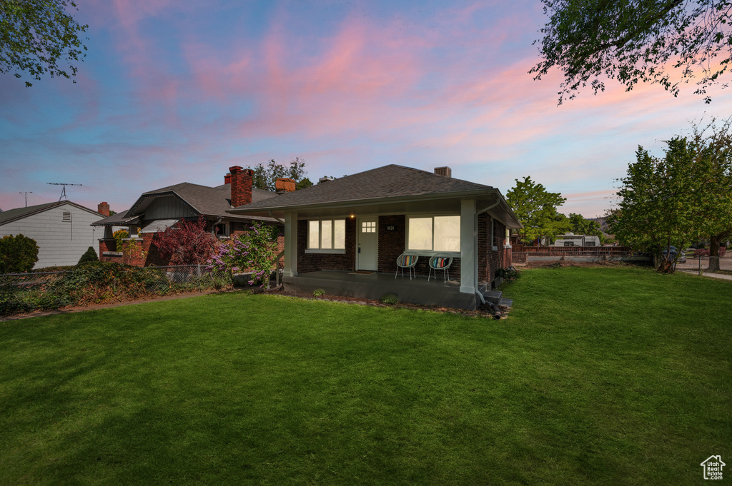 Back of house featuring a chimney, brick siding, and covered porch