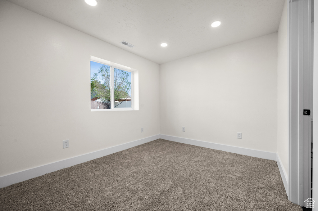 Empty room featuring carpet, recessed lighting, and baseboards