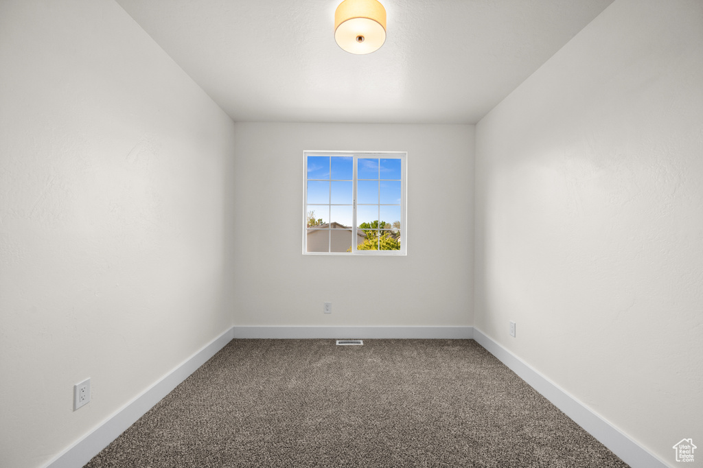 Carpeted empty room with baseboards