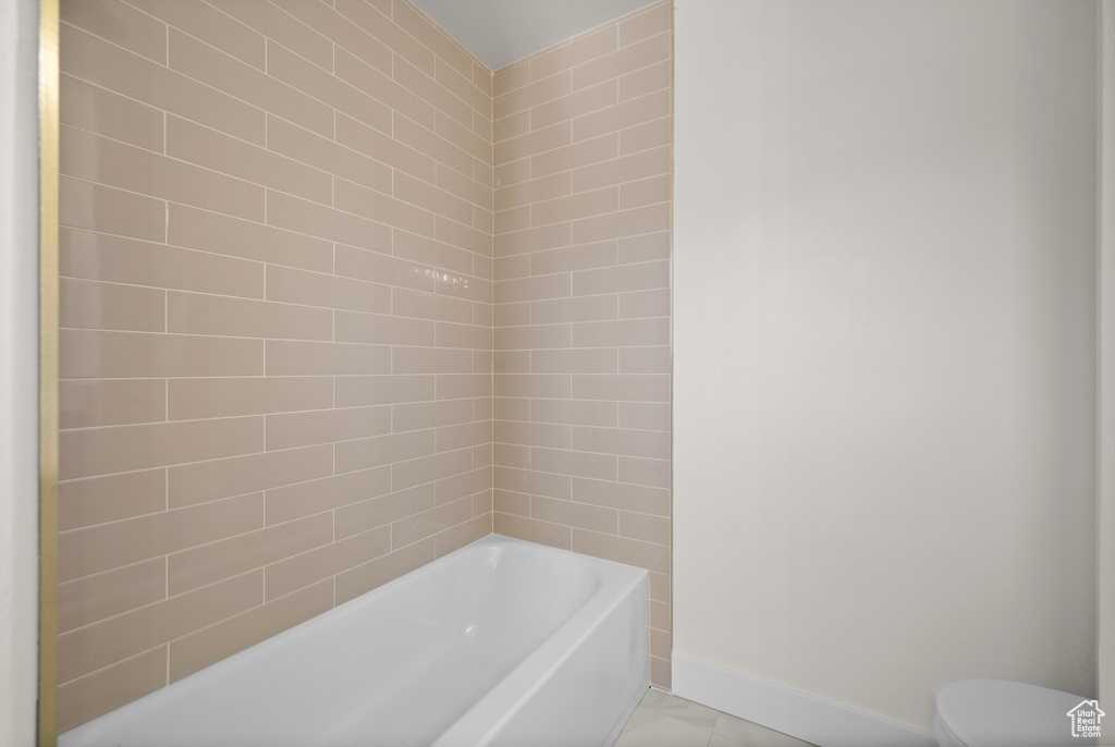 Full bath with a bath, baseboards, and toilet