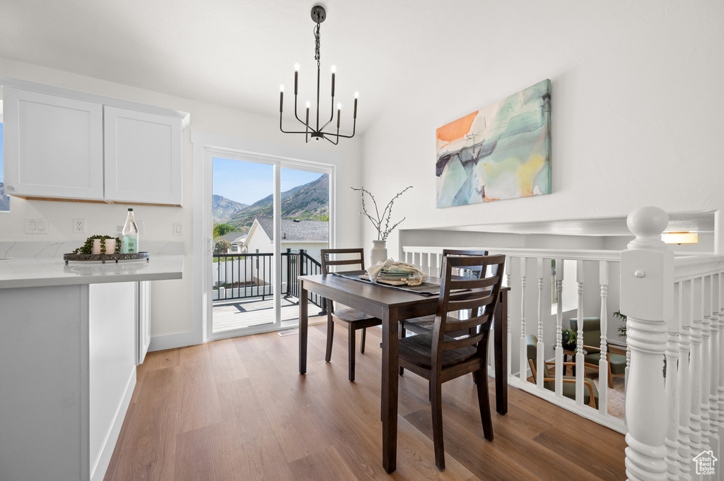 Dining room featuring a chandelier, wood finished floors, a mountain view, and baseboards