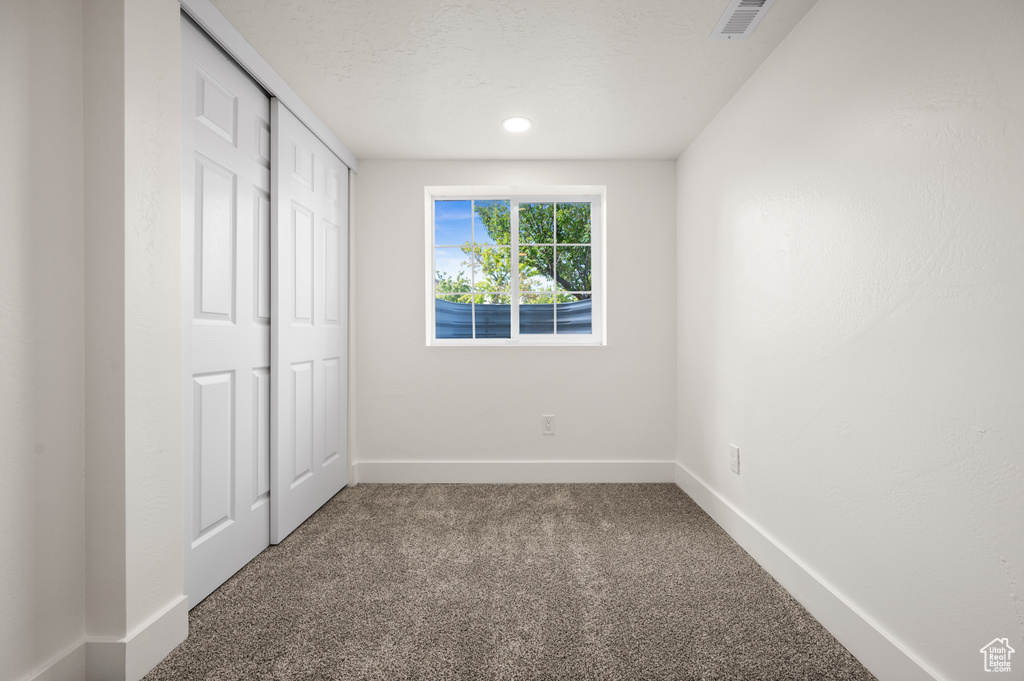 Unfurnished bedroom with carpet flooring, baseboards, and a closet