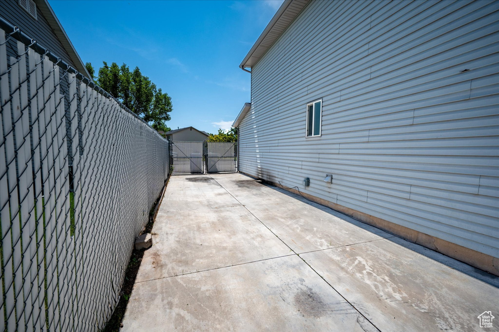 View of property exterior with a gate and a patio