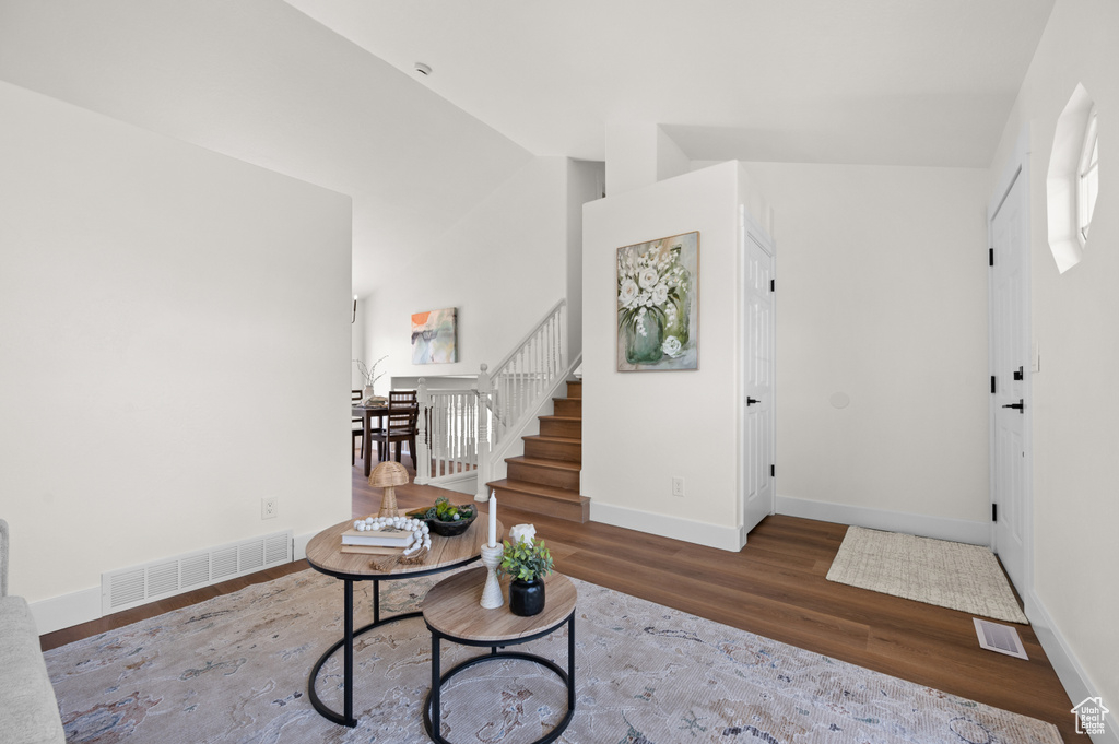 Entrance foyer featuring wood finished floors, stairway, and baseboards