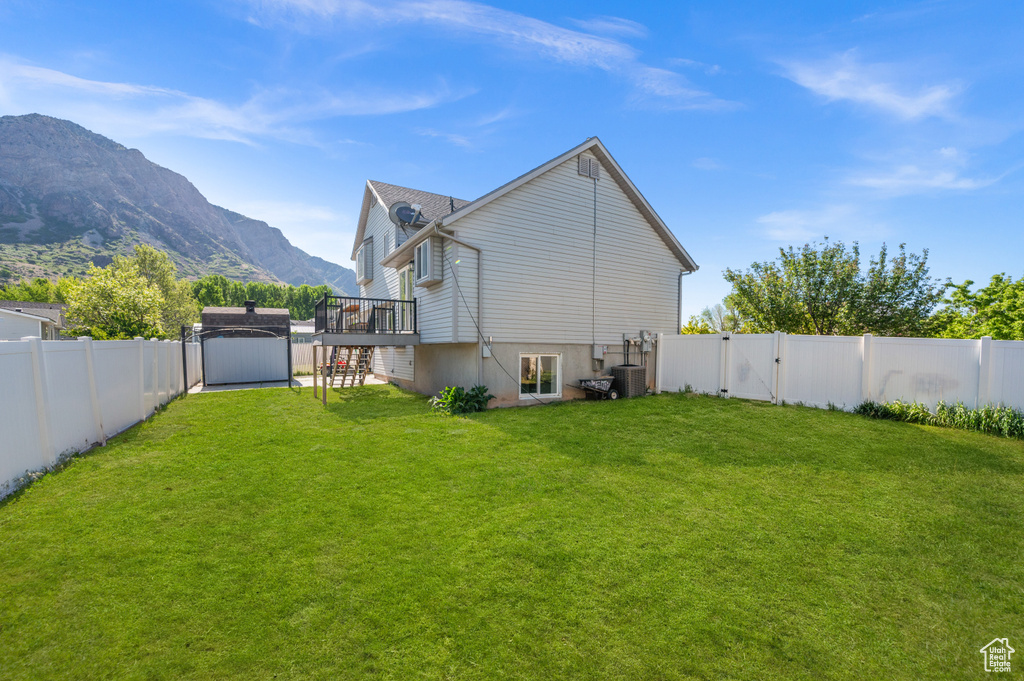 Back of house featuring a deck with mountain view and a gate