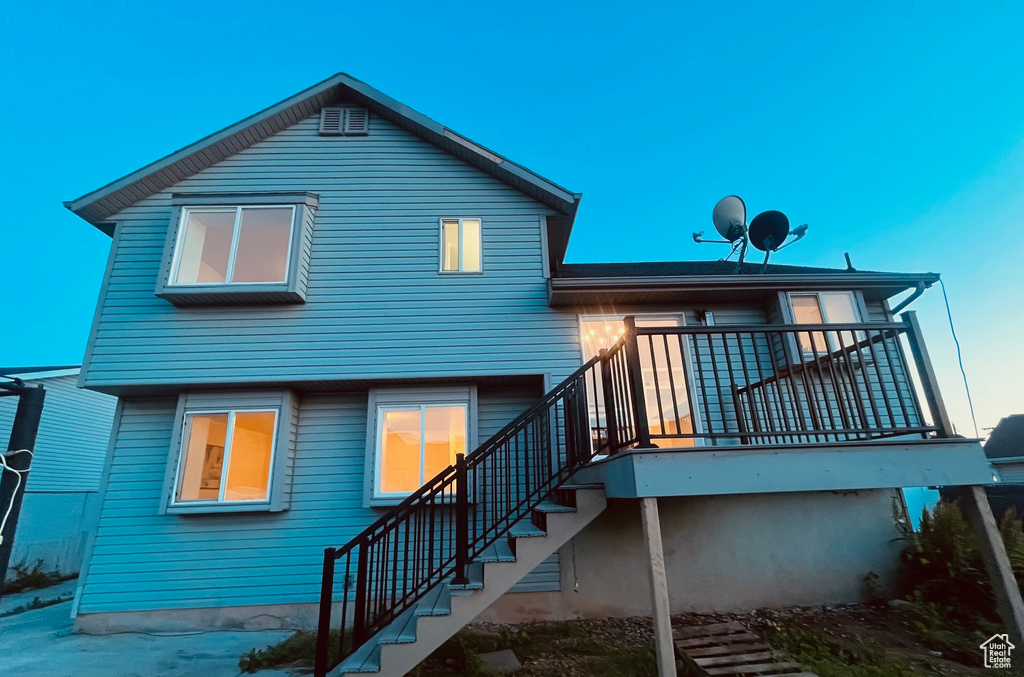 Back of property with stairs and a deck