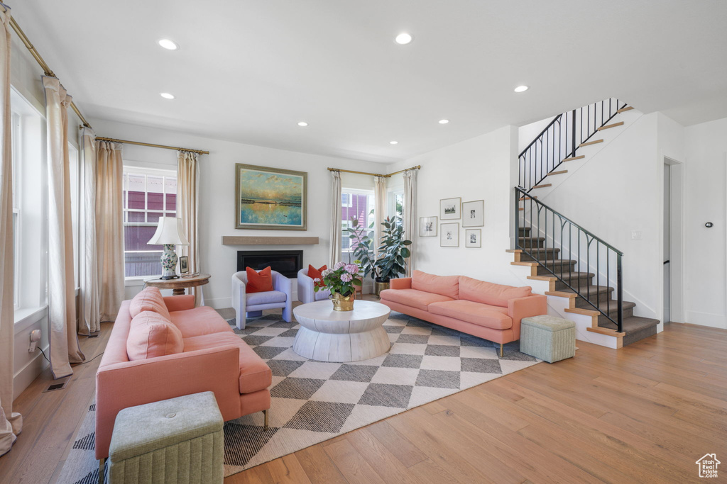 Living area featuring wood finished floors, plenty of natural light, recessed lighting, stairway, and a fireplace