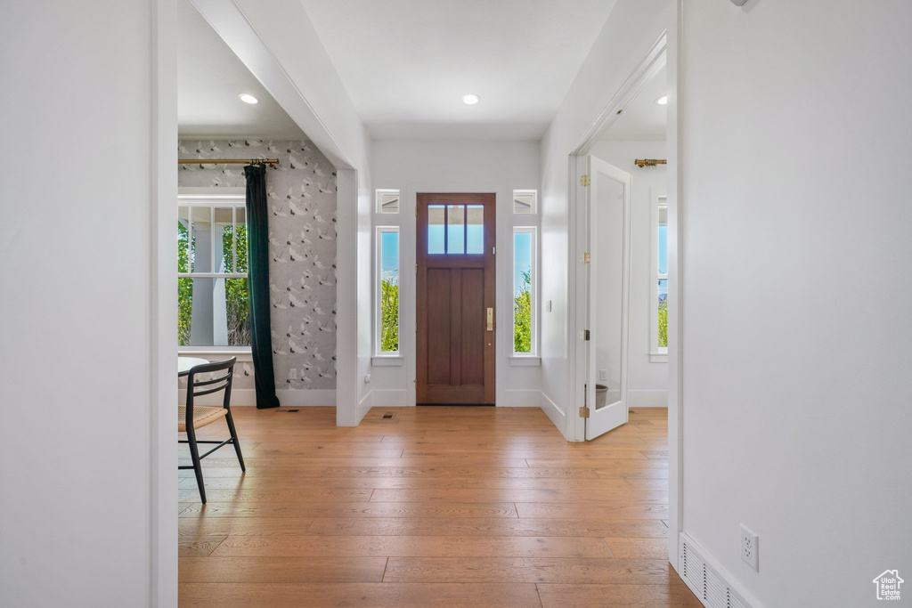 Foyer entrance with plenty of natural light, light wood-type flooring, baseboards, and recessed lighting