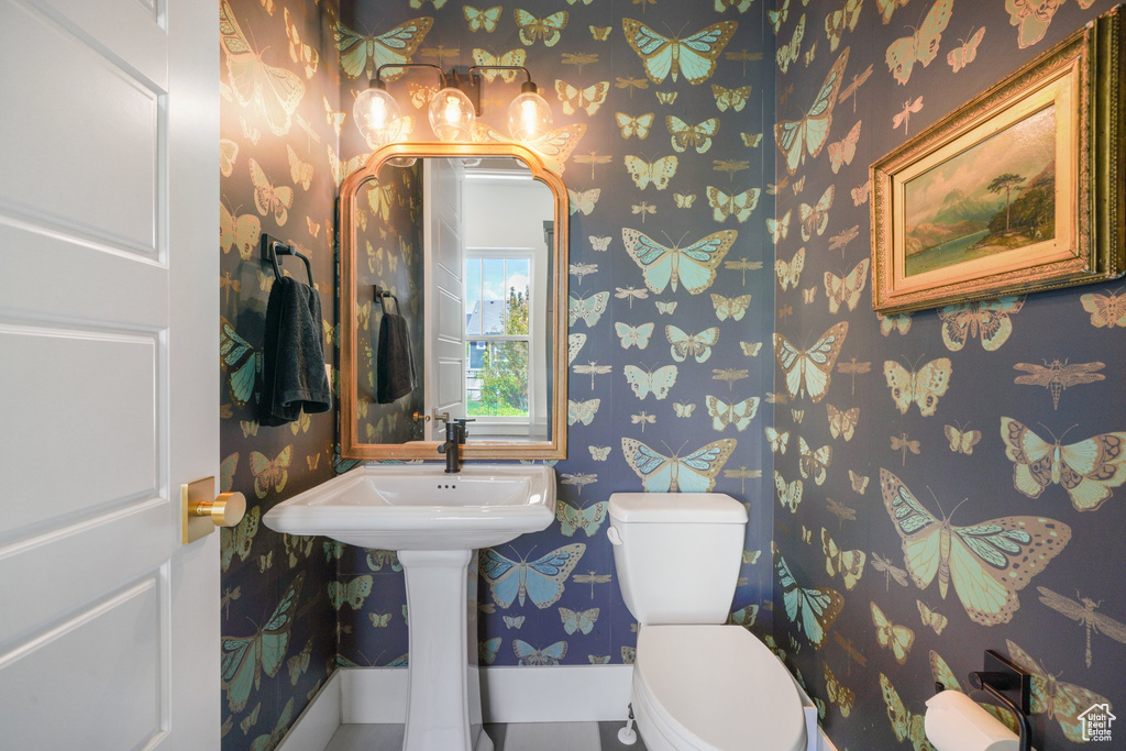 Bathroom featuring wallpapered walls and toilet