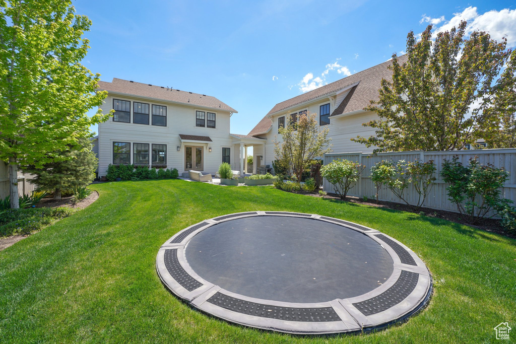 Back of house with a trampoline and french doors