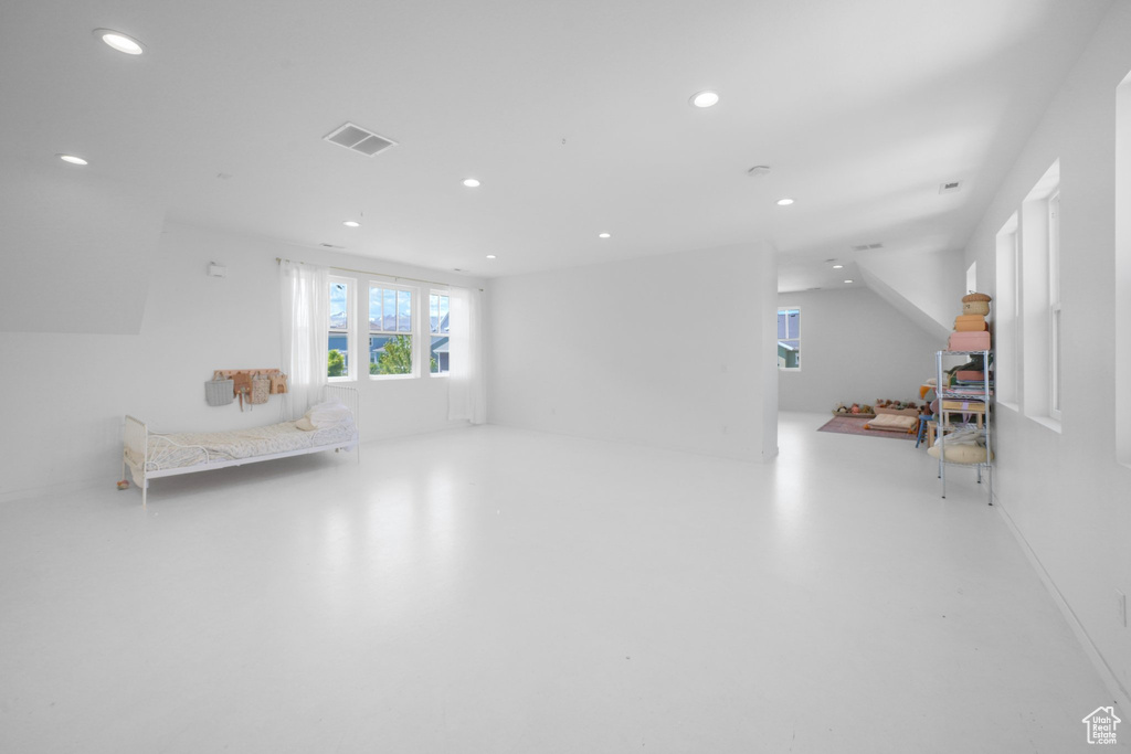 Bedroom with recessed lighting and finished concrete flooring