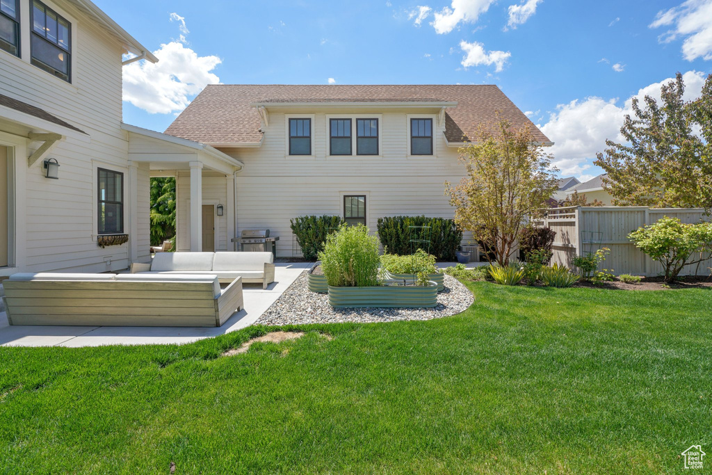 Rear view of house with an outdoor living space, roof with shingles, and a patio area
