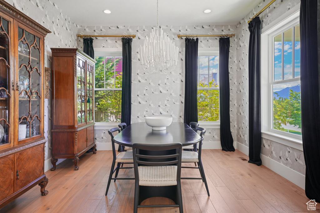 Dining area featuring light wood finished floors, baseboards, a chandelier, and recessed lighting
