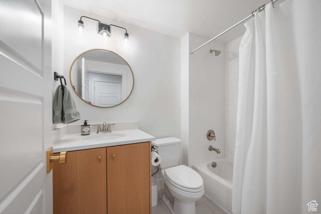 Full bath featuring toilet, vanity, and shower / bathtub combination with curtain