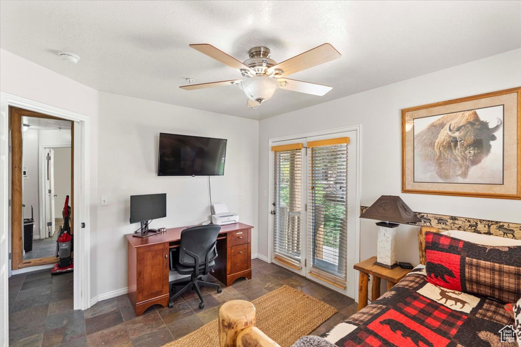 Office space with baseboards, stone finish flooring, and ceiling fan