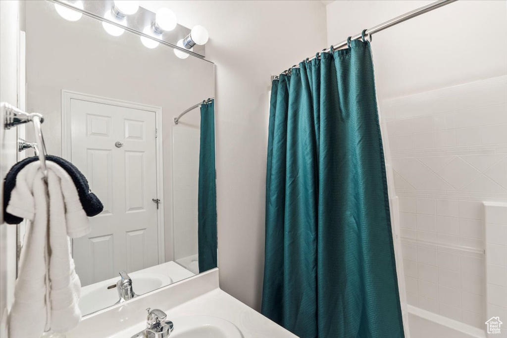 Bathroom with shower / bath combination with curtain and vanity