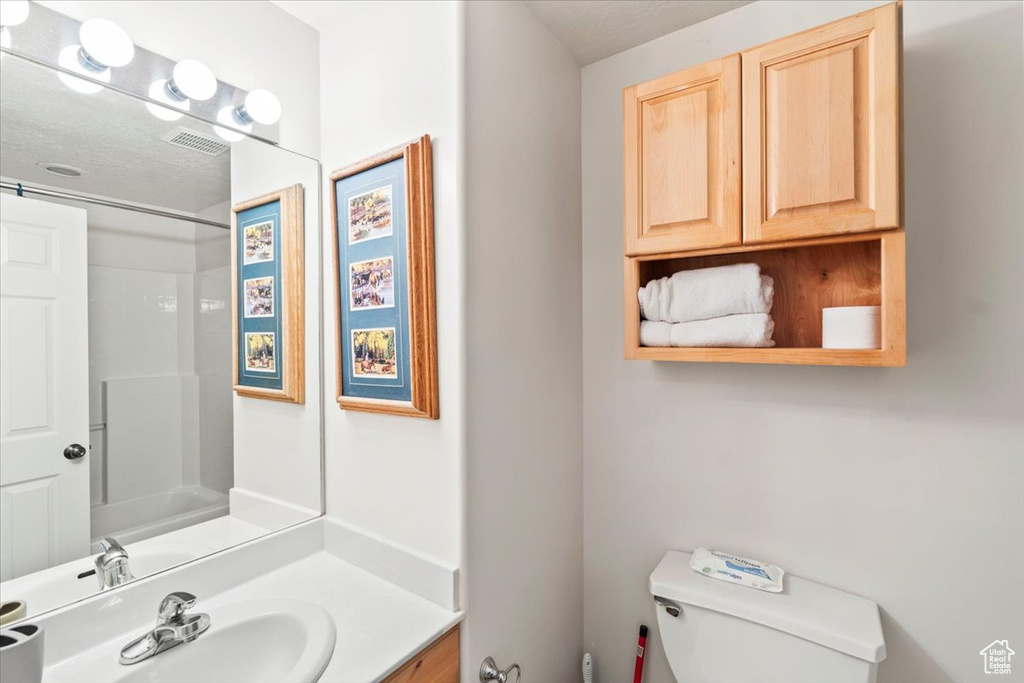Bathroom featuring toilet, visible vents, and vanity