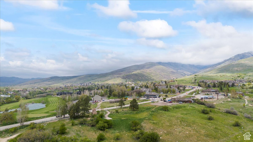 Property view of mountains with golf course view and a residential view
