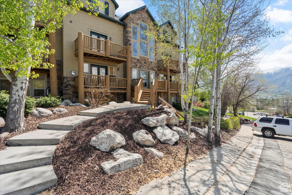 Exterior space with a balcony and stone siding