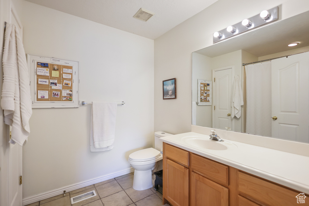 Full bath with tile patterned flooring, toilet, vanity, and baseboards