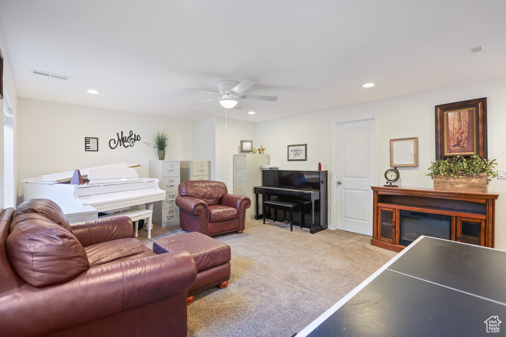 Living area with a ceiling fan, recessed lighting, and light carpet