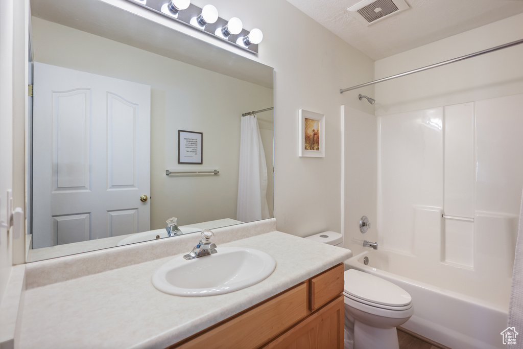 Full bath featuring toilet, vanity, and shower / bath combination with curtain