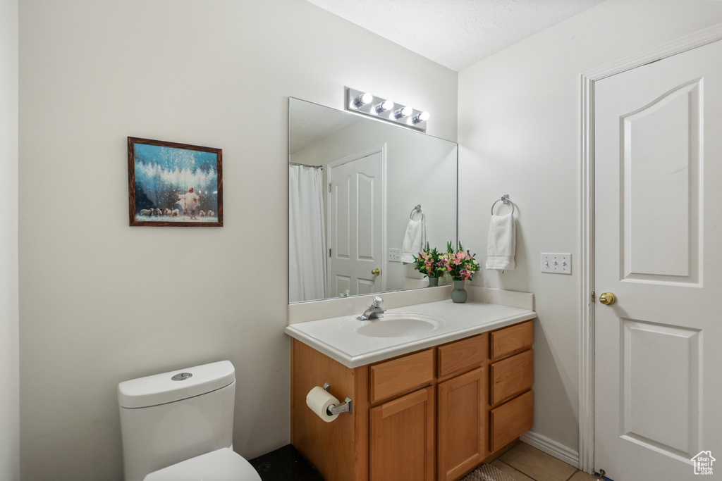 Bathroom with vanity, toilet, and tile patterned floors