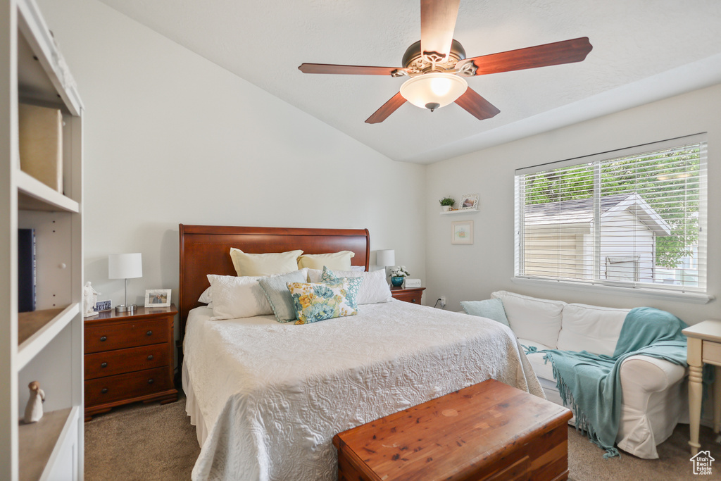 Carpeted bedroom with vaulted ceiling and ceiling fan
