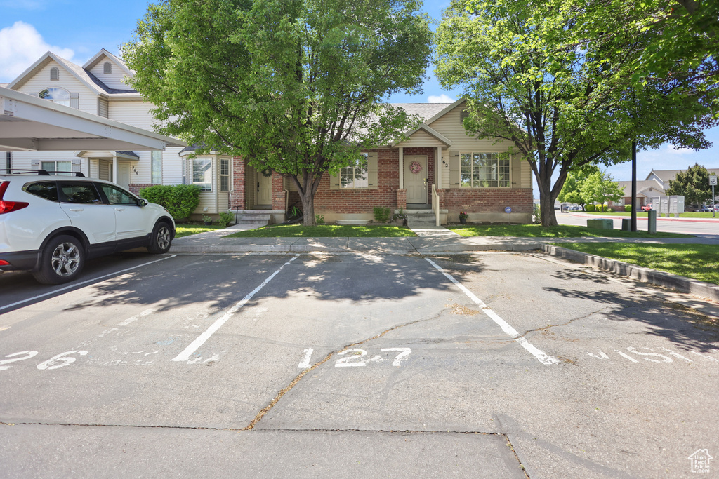 View of front facade with brick siding and uncovered parking