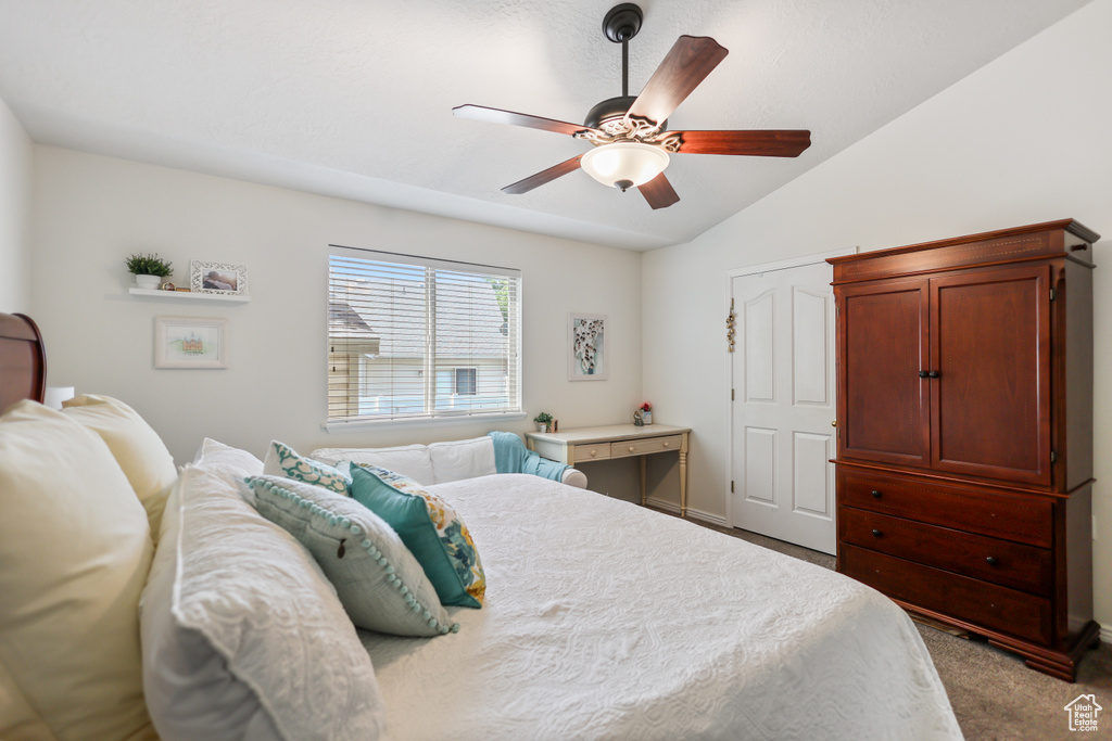 Carpeted bedroom with lofted ceiling and a ceiling fan