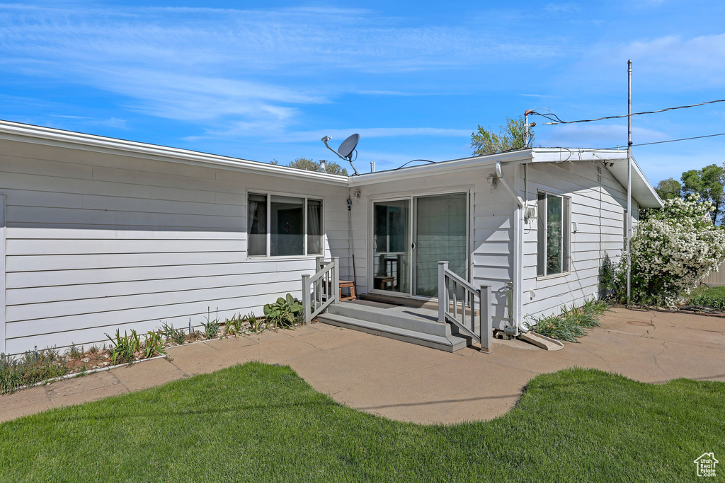 Rear view of house featuring a patio and a yard