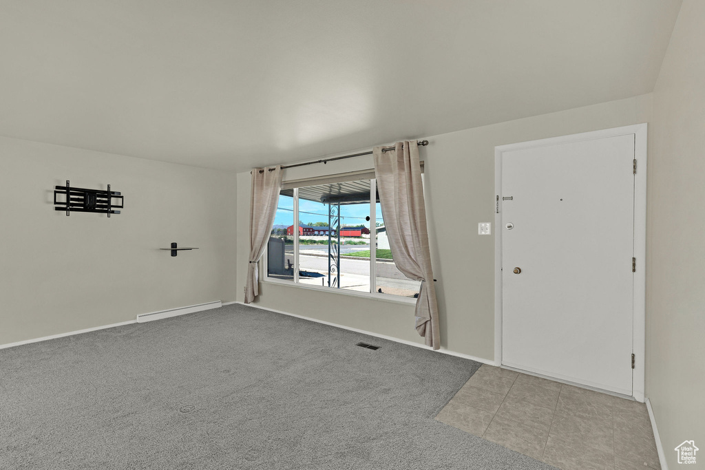 Foyer with baseboards, carpet floors, and a baseboard radiator