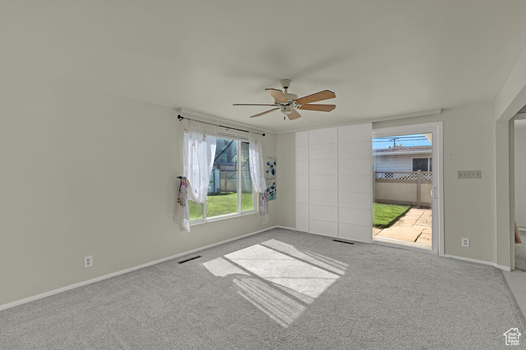 Empty room with ceiling fan, carpet flooring, and baseboards