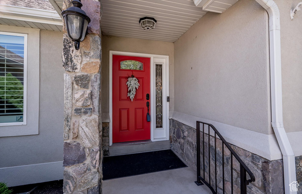 Entrance to property featuring stone siding and stucco siding