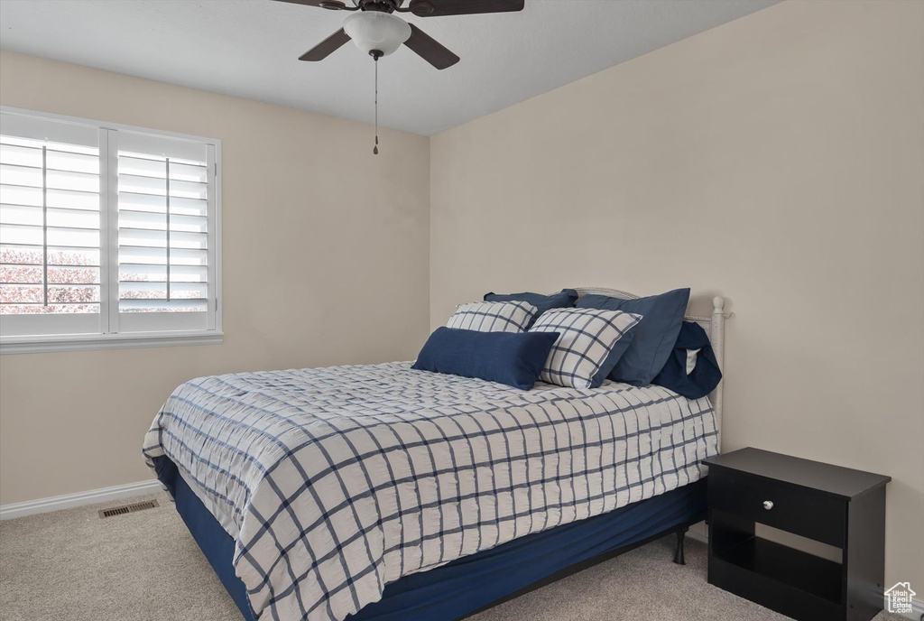 Bedroom with carpet flooring, baseboards, and a ceiling fan